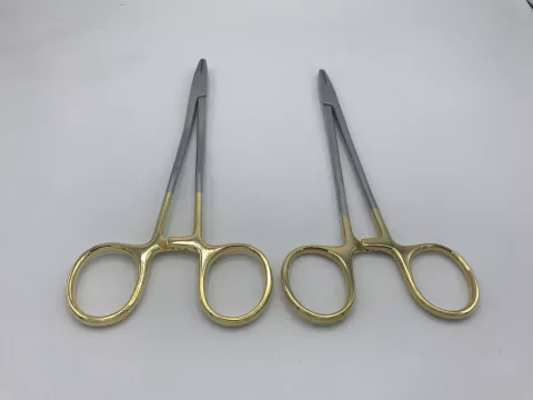 Straight and curved Mayo-Hegar needle-holder examples with gold-coloured rings — view 1